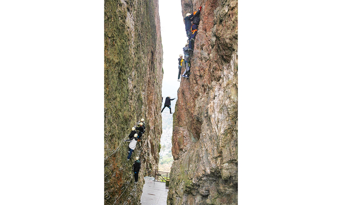 Tourists experience the thrill and excitement of Via Ferrata around Yandang Mountain, a national 5A-level scenic area, in Xianrentan village, East China's Zhejiang Province. Photo: VCG