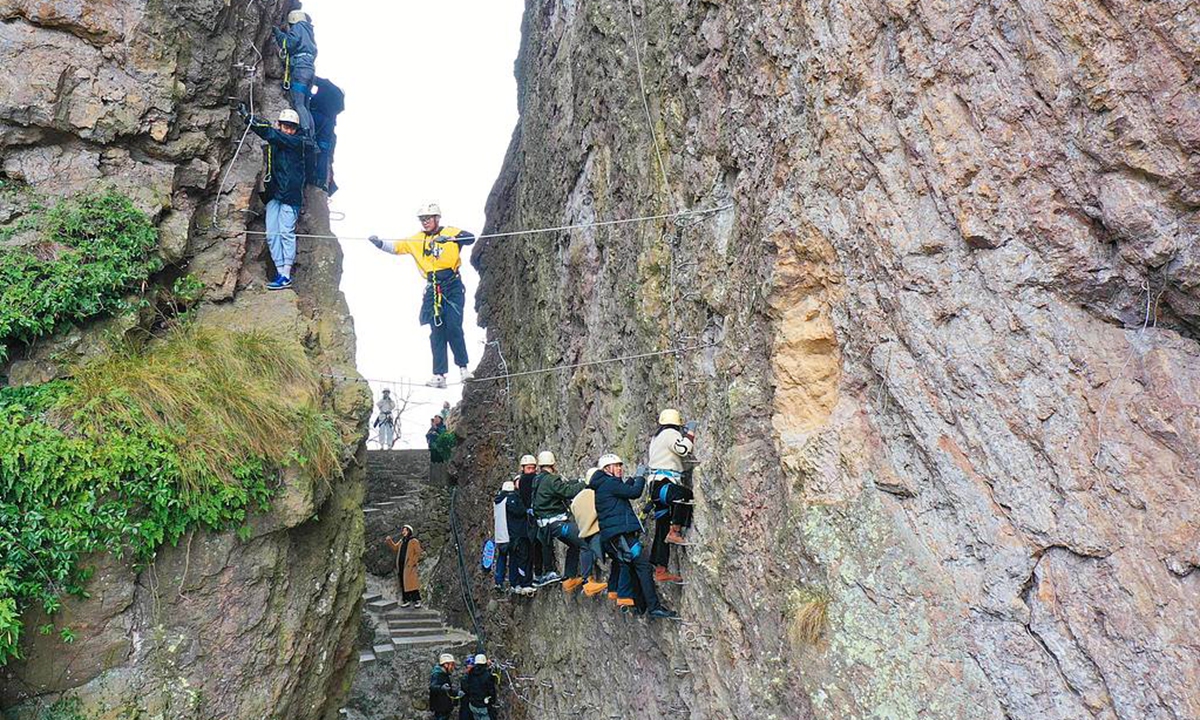 Tourists experience the thrill and excitement of Via Ferrata around Yandang Mountain, a national 5A-level scenic area, in Xianrentan village, East China's Zhejiang Province. Photo: VCG