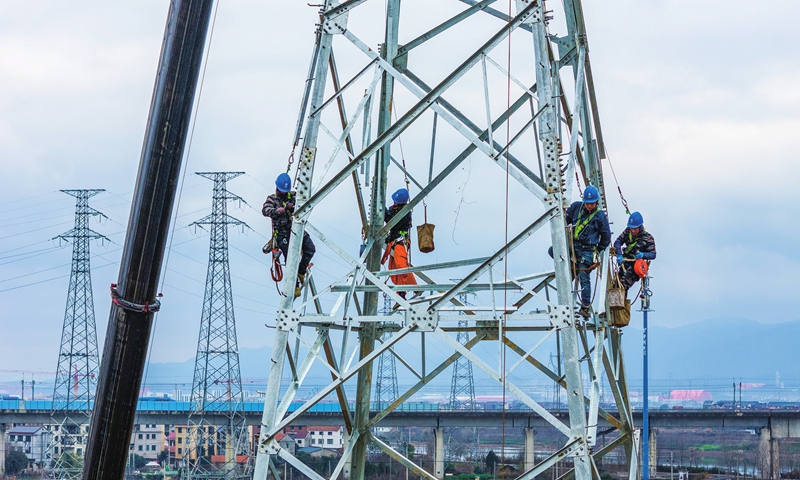 Workers erect transmission towers for a 110kV power line relocation project on February 21, 2025, in Wucheng district in Jinhua, East China's Zhejiang Province. The district has been implementing the 110kV power line relocation project since 2024 to meet the construction needs of key livelihood projects. 
Photo: VCG