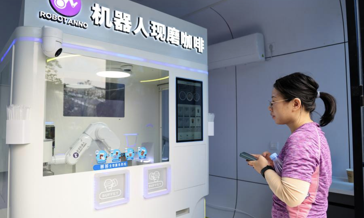 A visitor waits for a robot-made coffee at a park in Shenzhen, south China's Guangdong Province, Dec. 27, 2024. (Xinhua/Liang Xu)
