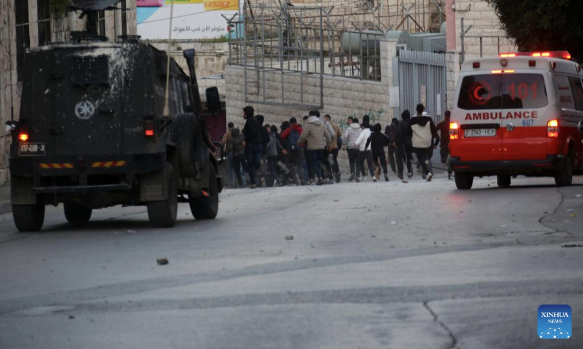 Palestinian youths run on a street during clashes with Israeli forces in the West Bank city of Nablus, on Feb. 25, 2025. (Photo by Nidal Eshtayeh/Xinhua)