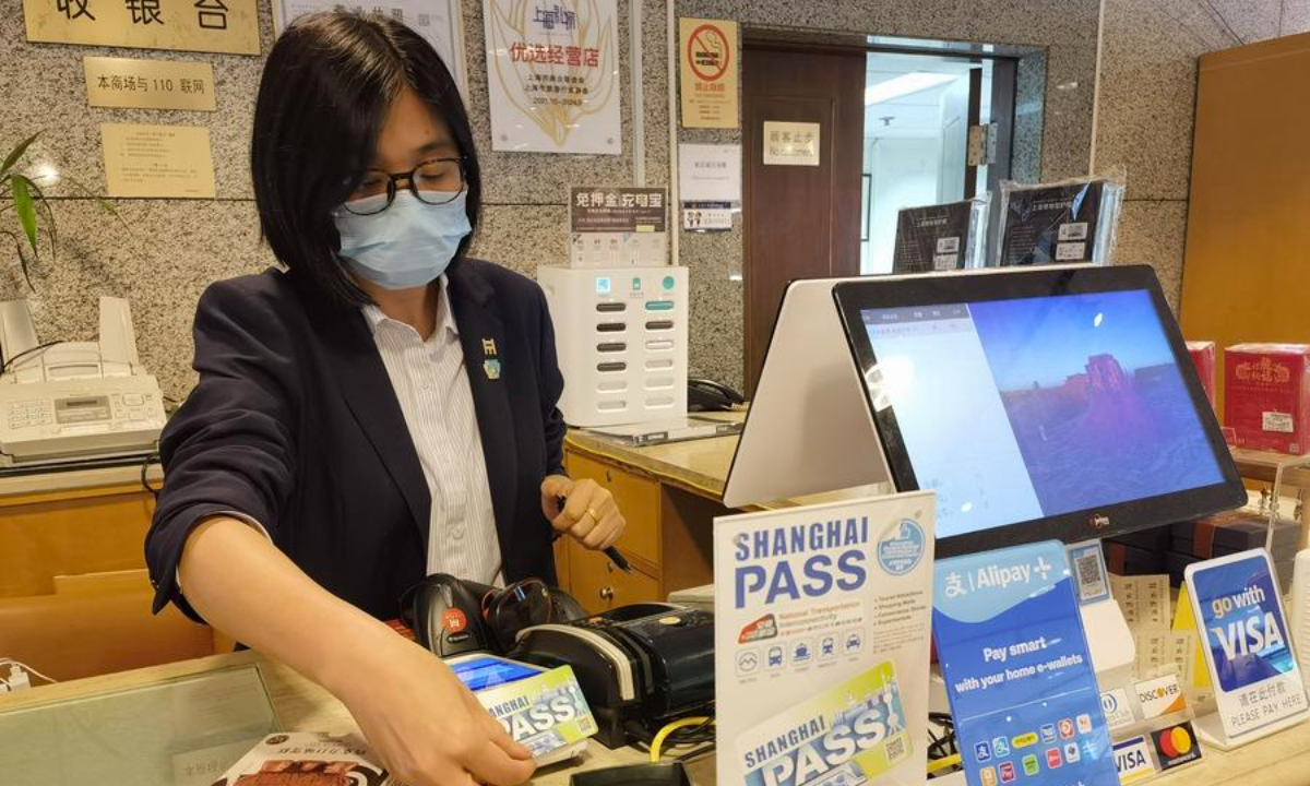 A clerk processes a payment with a shopper's Shanghai Pass multipurpose prepaid travel card at the gift shop of Shanghai Museum in east China's Shanghai Municipality on May 22, 2024. (Xinhua/Chen Aiping)