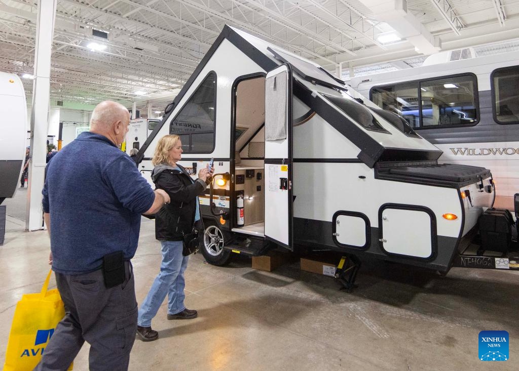 A woman films a travel trailer during the 2025 Toronto Spring Camping and RV Show in Mississauga, the Greater Toronto Area, Canada, on Feb. 27, 2025. Showcasing more than 450 RVs, this annual show kicked off here on Thursday and will last until March 2. (Photo: Xinhua)
