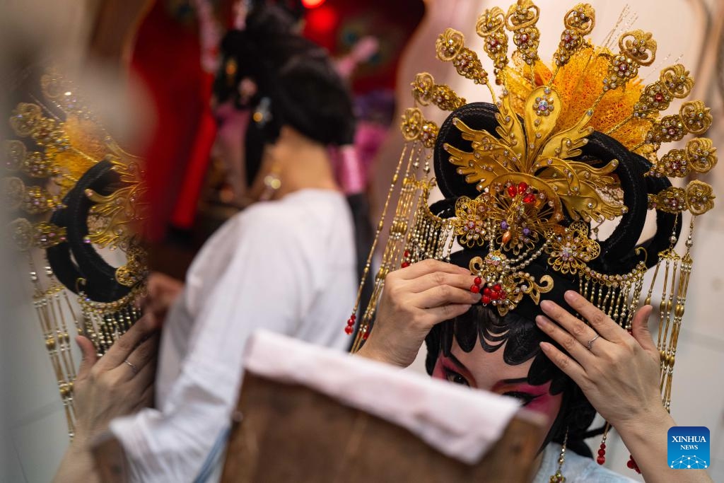 An actress puts on hair decorations at backstage during a five-day Cantonese Opera show to celebrate the second day of the second month in the Chinese lunar calender, in Macao, south China, Feb. 27, 2025. (Photo: Xinhua)