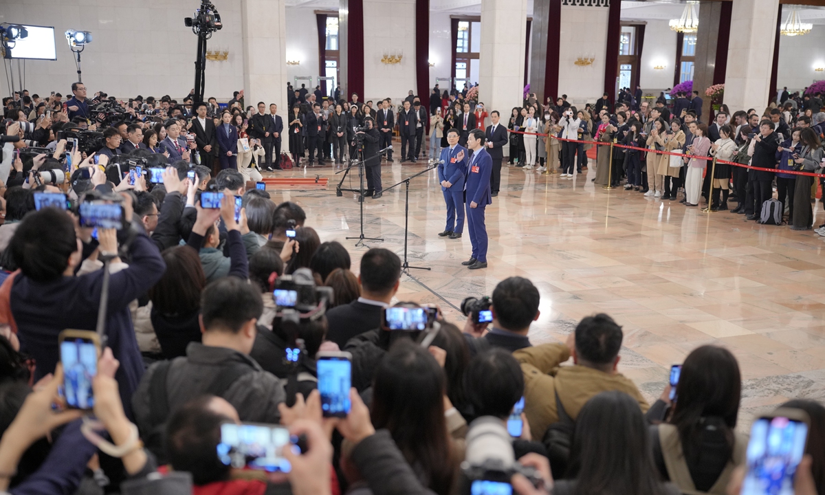 Lei Jun (right), founder and CEO of Xiaomi, and Zhou Yunjie (left), chairman and CEO of Haier Group, who are both deputies to the 14th National People's Congress (NPC), attend the first 