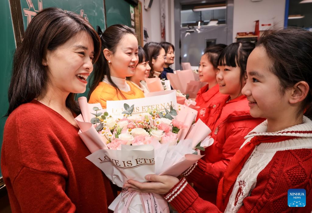 Students present flowers to their teachers at a primary school in Wuhan, central China's Hubei Province, March 6, 2025. Various activities are held across the country to mark the International Women's Day. (Photo: Xinhua)