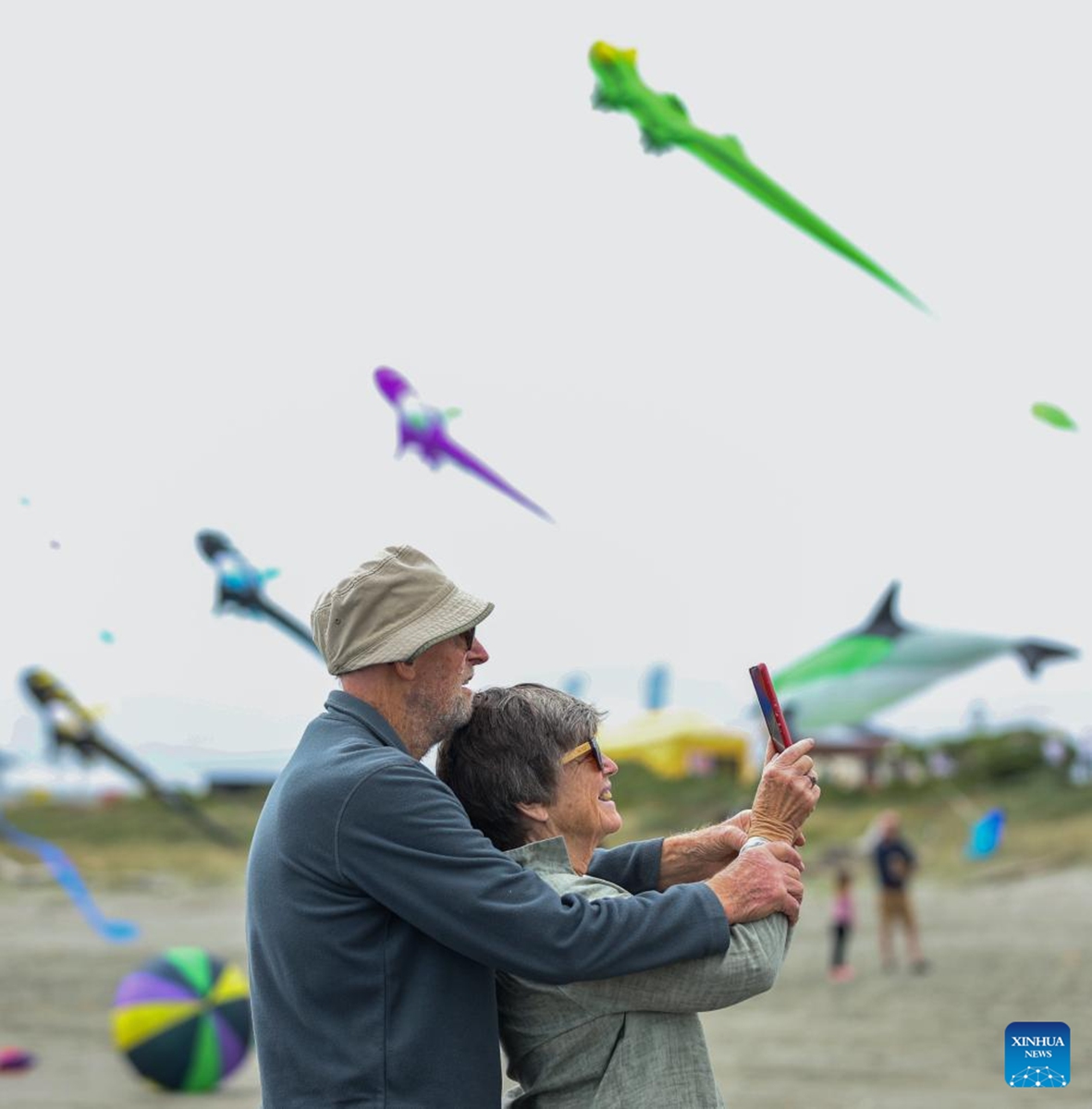 A couple takes photos at Otaki beach, New Zealand, March 8, 2025. Otaki Kite Festival was held here on Saturday. Photo: Xinhua