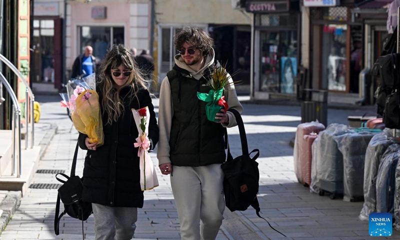 People holding flowers walk on a street in Bitola, North Macedonia, on the occasion of International Women's Day, March 8, 2025. Photo: Xinhua