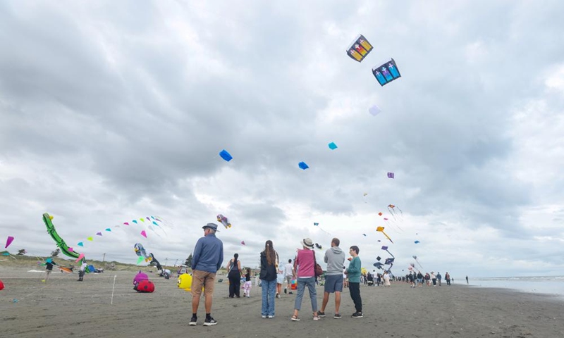 People watch flying kites at Otaki beach, New Zealand, March 8, 2025. Otaki Kite Festival was held here on Saturday. Photo: Xinhua