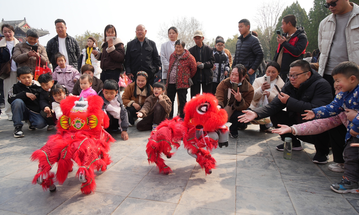 A lion dance performance by two robotic dogs attracts a large crowd of spectators at the Taihao Fuxiling Cultural Tourism Area in the city of Zhoukou, Central China's Henan Province, on March 9, 2025. Photo: VCG 