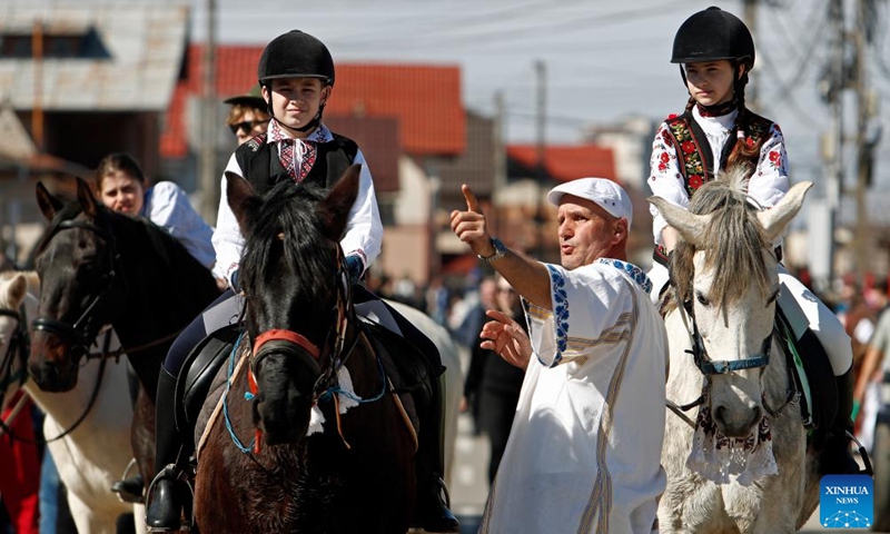 A man shows direction to children on horses during the celebration of the traditional Tudorita holiday, also known as the Easter of Horses, in Targoviste, Romania, March 8, 2025. Easter of Horses is celebrated by the local Bulgarian community and symbolizes the start of agricultural work in the new year. Photo: Xinhua