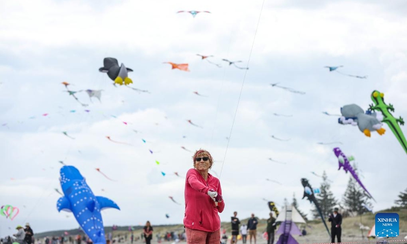 A senior woman flies a kite at Otaki beach, New Zealand, March 8, 2025. Otaki Kite Festival was held here on Saturday. Photo: Xinhua