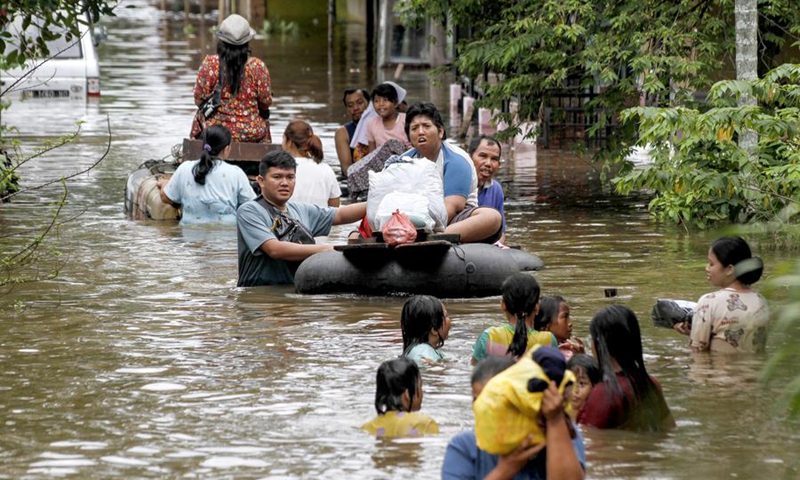 People wade through flood water after heavy rain and overflow of Siak River in Pekanbaru, Riau province, Indonesia, March 6, 2025. Photo: Xinhua