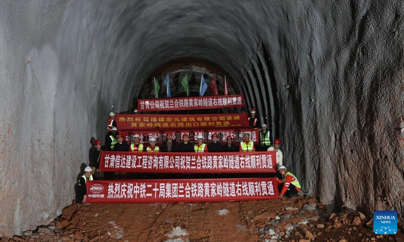 Staff members pose for a group photo to celebrate the drill-through of the right track tunnel of the Huangjialing Tunnel at the construction site in Linxia Hui Autonomous Prefecture, northwest China's Gansu Province, March 9, 2025. The right track tunnel of the Huangjialing Tunnel was drilled through on Sunday. The Huangjialing Tunnel, with a total length of 5,881 meters, is a key project of Lanzhou-Hezuo high-speed railway, a part of China's high-speed rail network that centers around eight main vertical lines linking the north and south and eight horizontal lines connecting the east and west. Photo: Xinhua