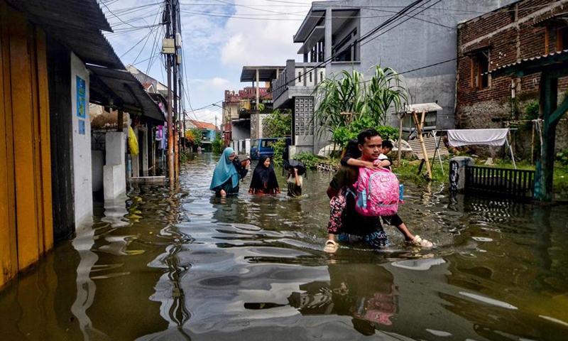 People wade through floodwater after heavy rain in Dayeuhkolot, Bandung, Indonesia, March 9, 2025. Photo: Xinhua