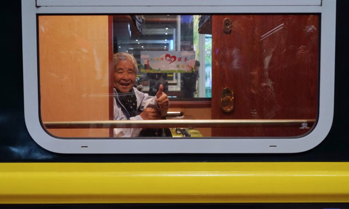 A passenger poses for photos on a tourist train for seniors in Beijing, capital of China, March 15, 2025. A tourist train for seniors departed from north China's Tianjin on Saturday. Carrying a total of 452 silver-haired passengers from the Beijing-Tianjin-Hebei region, the train is on a 12-day journey and will visit a series of tourist areas in Jiangxi, Hunan and Guangdong provinces. (Xinhua/Zhang Chenlin)