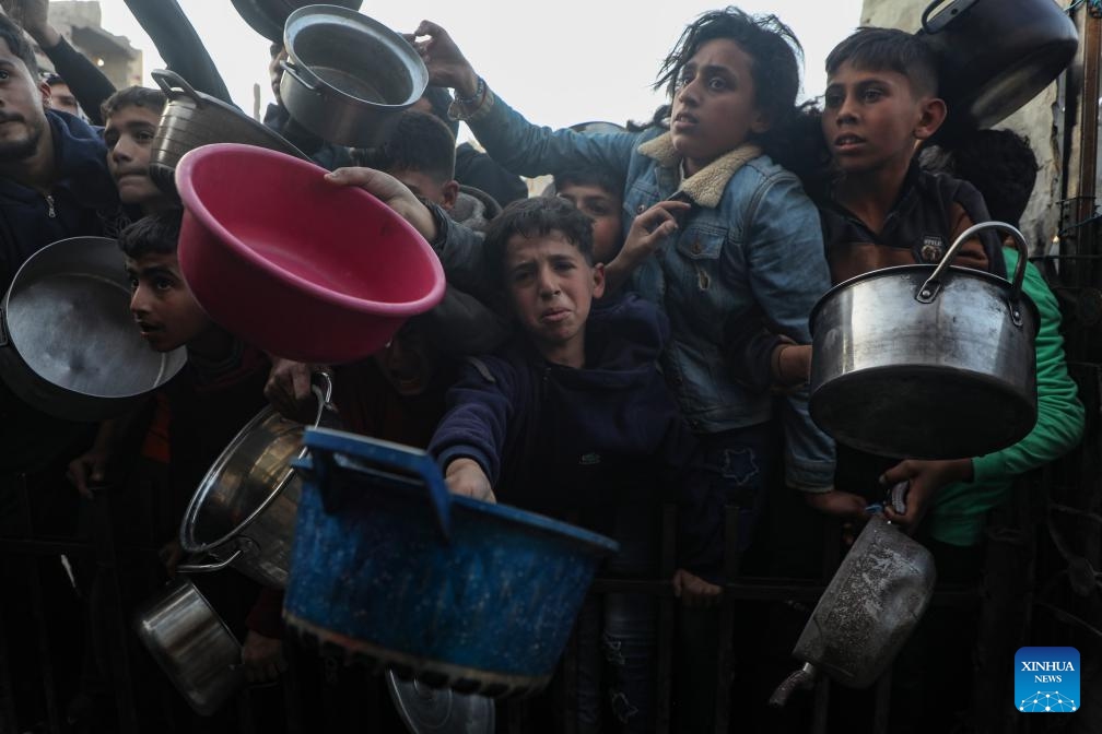 People try to get food at a charity kitchen in Jabalia refugee camp, northern Gaza Strip, on March 11, 2025. (Photo: Xinhua)