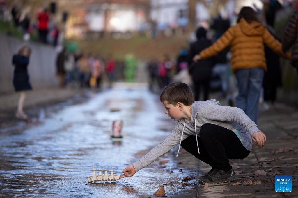 A boy lets his homemade miniature boat down the stream during an event to celebrate the arrival of spring in Ljubljana, Slovenia on March 11, 2025. (Photo: Xinhua)