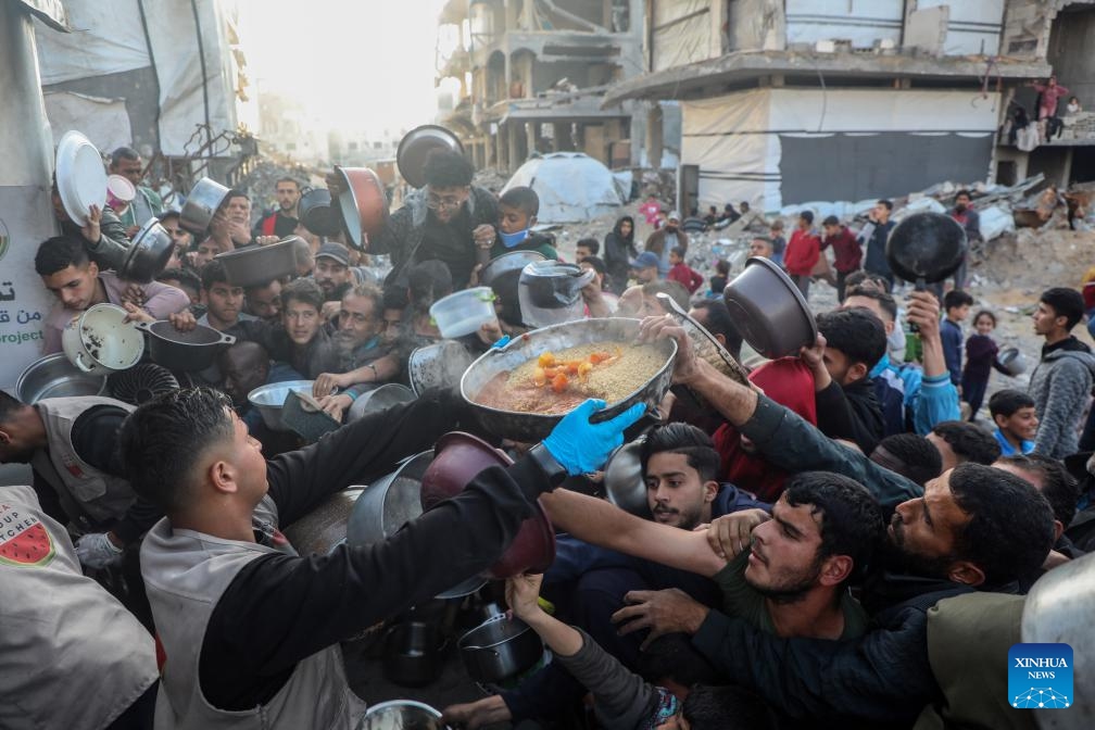People try to get food at a charity kitchen in Jabalia refugee camp, northern Gaza Strip, on March 11, 2025. (Photo: Xinhua)