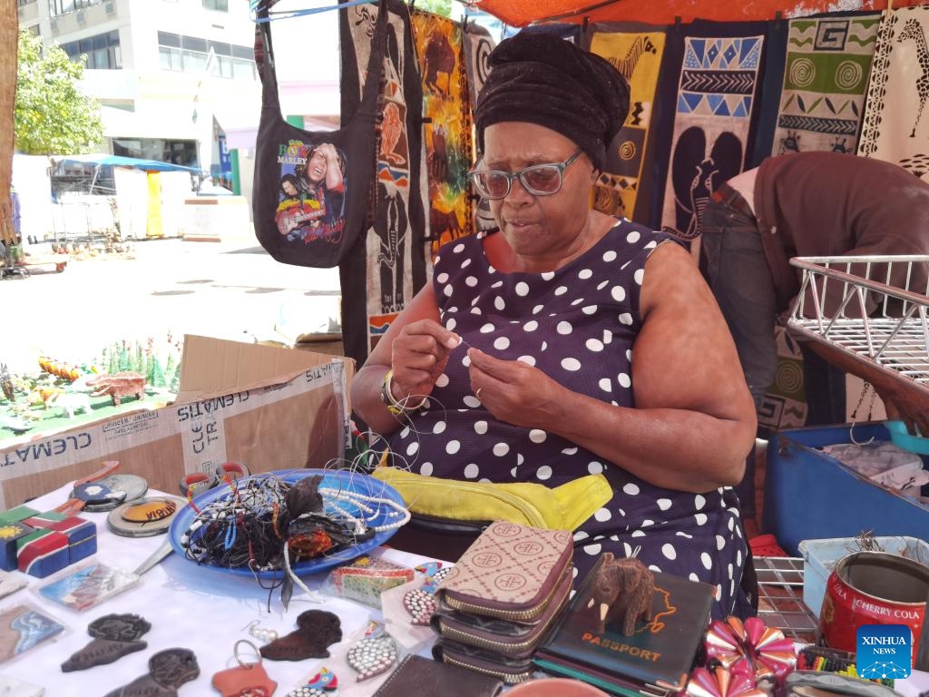 An artist makes jewelry at a street art market in Windhoek, Namibia, on March 8, 2025 (Photo: Xinhua)