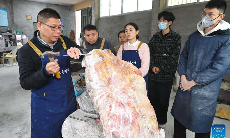 Craft artist Chen Lizhong (1st L) instructs students on Shoushan stone carvings at a studio in Fuzhou, southeast China's Fujian Province, March 5, 2025. Fuzhou is home to a rich intangible cultural heritage, including Shoushan stone carvings, Fuzhou bodiless lacquerware, wood carvings, and oil-paper umbrellas, etc. (Photo: Xinhua)