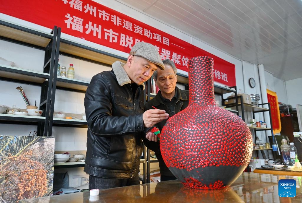 Craft artist Chen Tiangan (R) instructs a student on lacquerware technique at a studio in Fuzhou, southeast China's Fujian Province, March 6, 2025. Fuzhou is home to a rich intangible cultural heritage, including Shoushan stone carvings, Fuzhou bodiless lacquerware, wood carvings, and oil-paper umbrellas, etc. (Photo: Xinhua)
