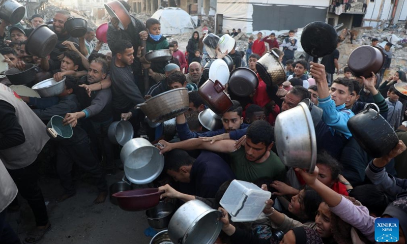 People try to get food at a charity kitchen in Jabalia refugee camp, northern Gaza Strip, on March 11, 2025. (Photo: Xinhua)