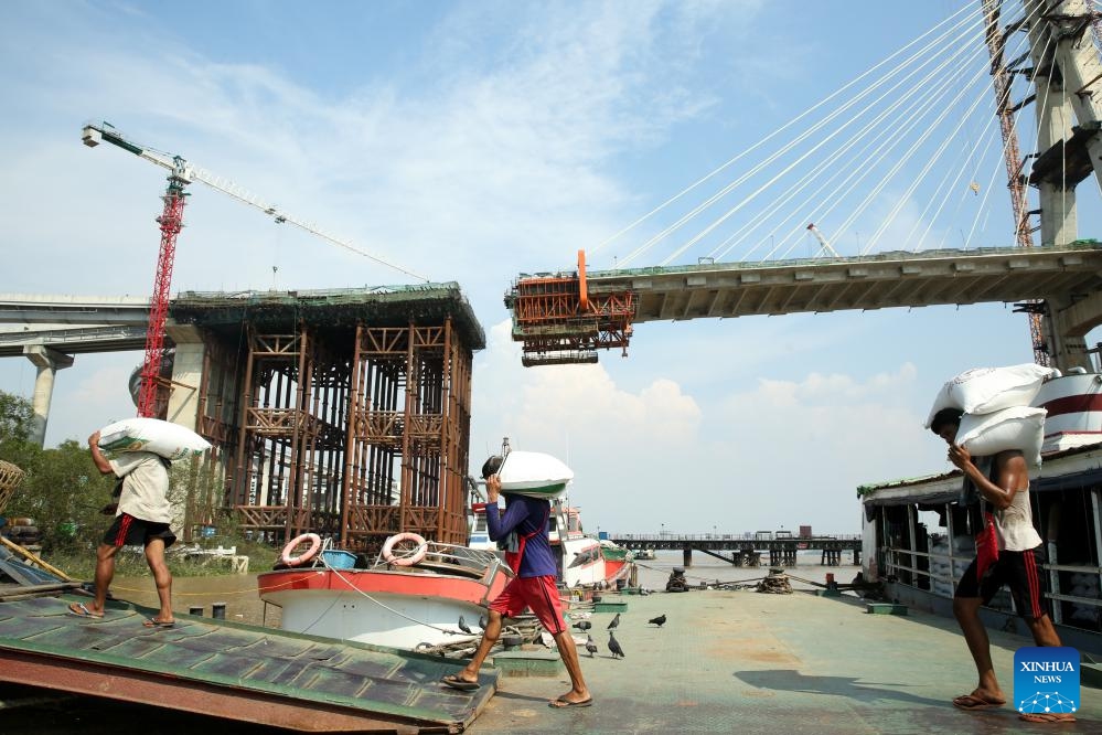 Workers unload bags of rice from a cargo boat at a jetty in Yangon, Myanmar, March 11, 2025. Myanmar's exports of rice and broken rice in the first 11 months of the 2024-25 fiscal year reached over 2.37 million tons, according to the Myanmar Rice Federation on Tuesday. (Photo: Xinhua)