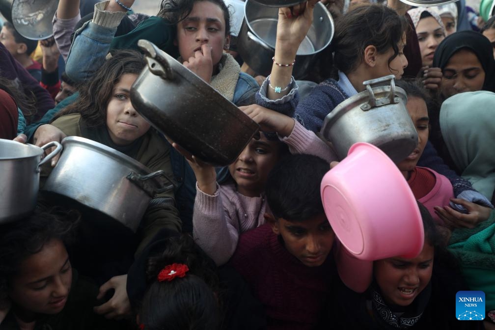 People try to get food at a charity kitchen in Jabalia refugee camp, northern Gaza Strip, on March 11, 2025. (Photo: Xinhua)