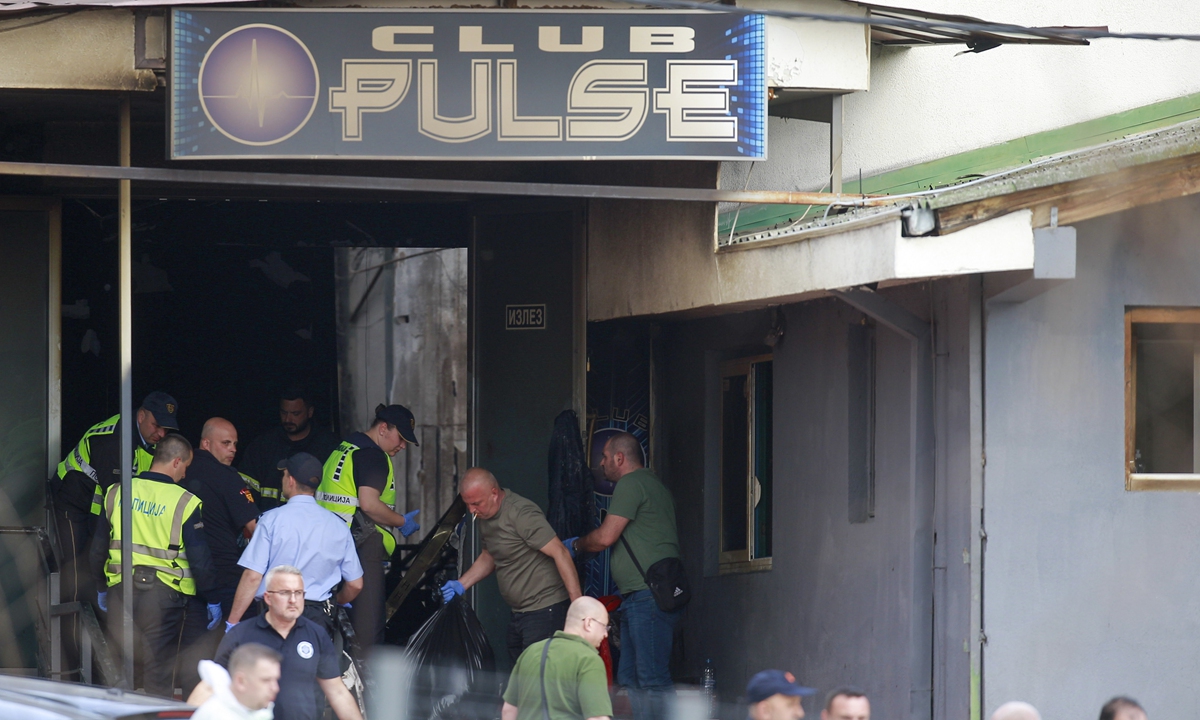 Police officers hold plastic bags on the site of a nightclub in the town of Kocani, North Macedonia, Sunday, March 16, 2025, following a massive fire in the nightclub early Sunday. Photo: AFP
