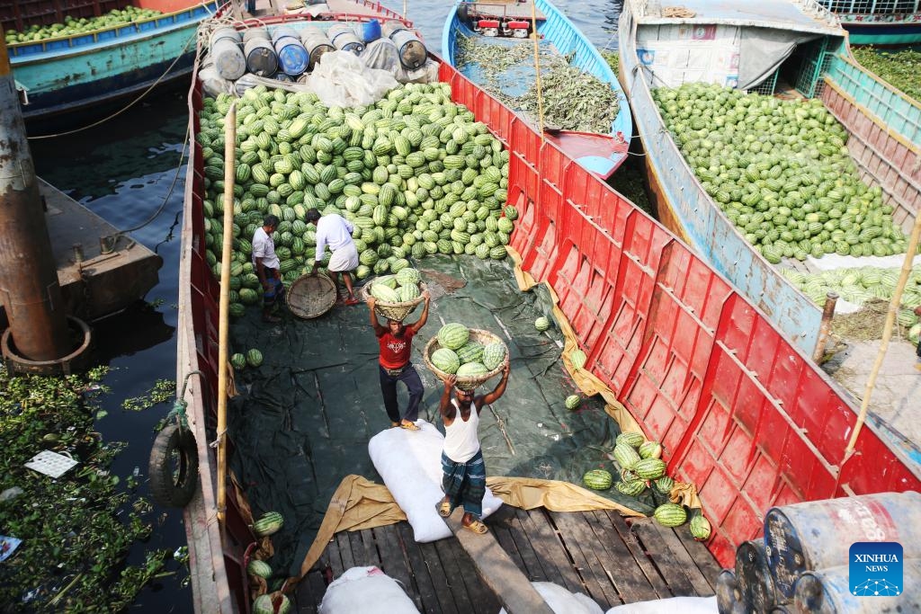 Workers unload watermelons from boats at Sadarghat terminal in Dhaka, Bangladesh, March 16, 2025. (Photo: Xinhua)