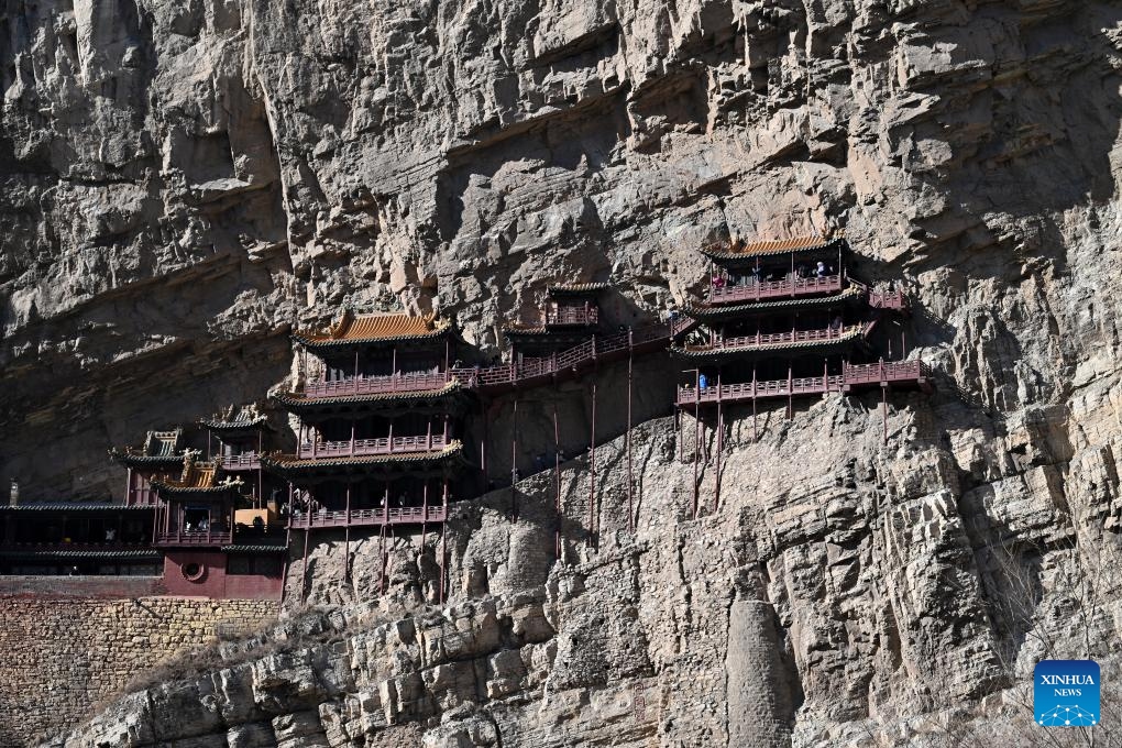 This photo taken on Feb. 28, 2025 shows the Hanging Temple, or Xuankong Temple, in Hunyuan County, Datong City in north China's Shanxi Province. Built over 1,500 years ago, the temple is notable for its location on a sheer precipice. The structure is kept in place with wooden beams inserted into holes chiseled into the cliffs. The main supportive structure is hidden inside the bedrock. The temple is located in a deep valley, and the body of the building hangs from the side of a cliff under a prominent peak, protecting the temple from rain erosion and sunlight. (Photo: Xinhua)