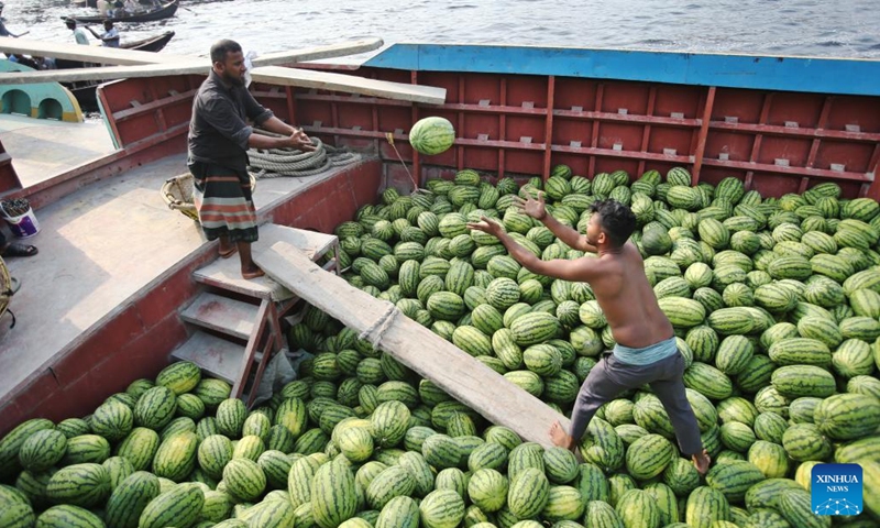 Workers unload watermelons from boats at Sadarghat terminal in Dhaka, Bangladesh, March 16, 2025. (Photo: Xinhua)