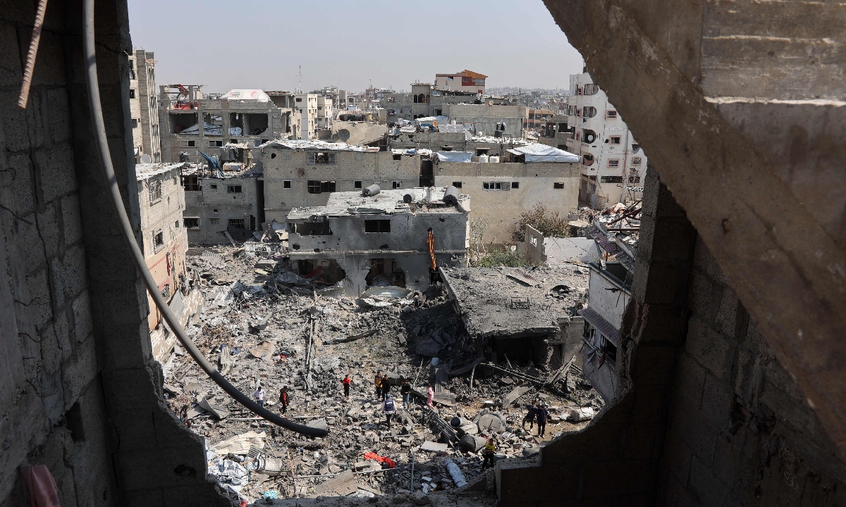 Palestinians salvage items from a destroyed house in the Shujaiya district in eastern Gaza City on March 18, 2025. Photo: VCG 