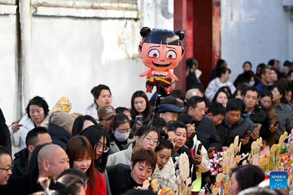 People view dough figurines in Lancheng Township of Lanxian County, north China's Shanxi Province, March 18, 2025. Lanxian dough figurine making was listed as a national-level intangible cultural heritage in 2014. The dough figurines can help revive people's memories of childhood and bear good wishes for the future. (Photo: Xinhua)