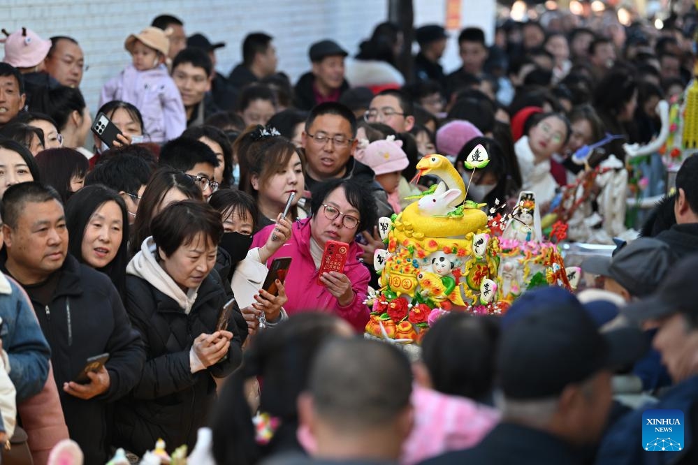 People view dough figurines in Lancheng Township of Lanxian County, north China's Shanxi Province, March 18, 2025. Lanxian dough figurine making was listed as a national-level intangible cultural heritage in 2014. The dough figurines can help revive people's memories of childhood and bear good wishes for the future. (Photo: Xinhua)