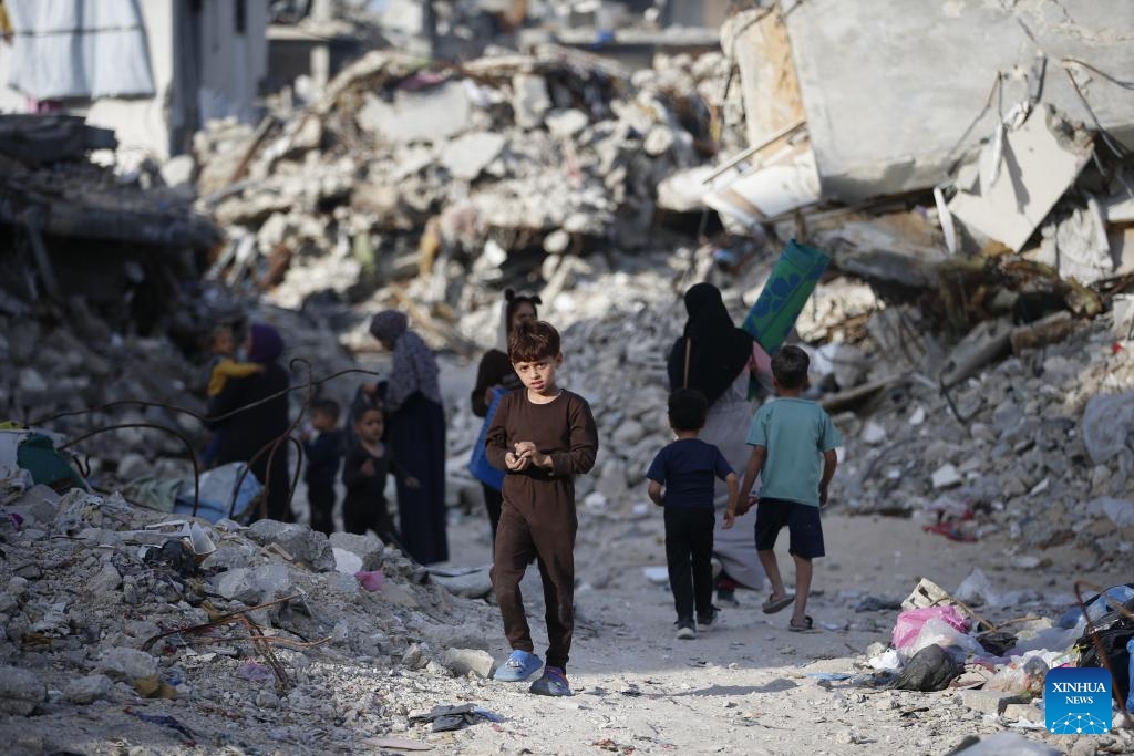 Palestinians walk among destroyed buildings in Jabalia in northern Gaza Strip on March 17, 2025. (Photo: Xinhua)