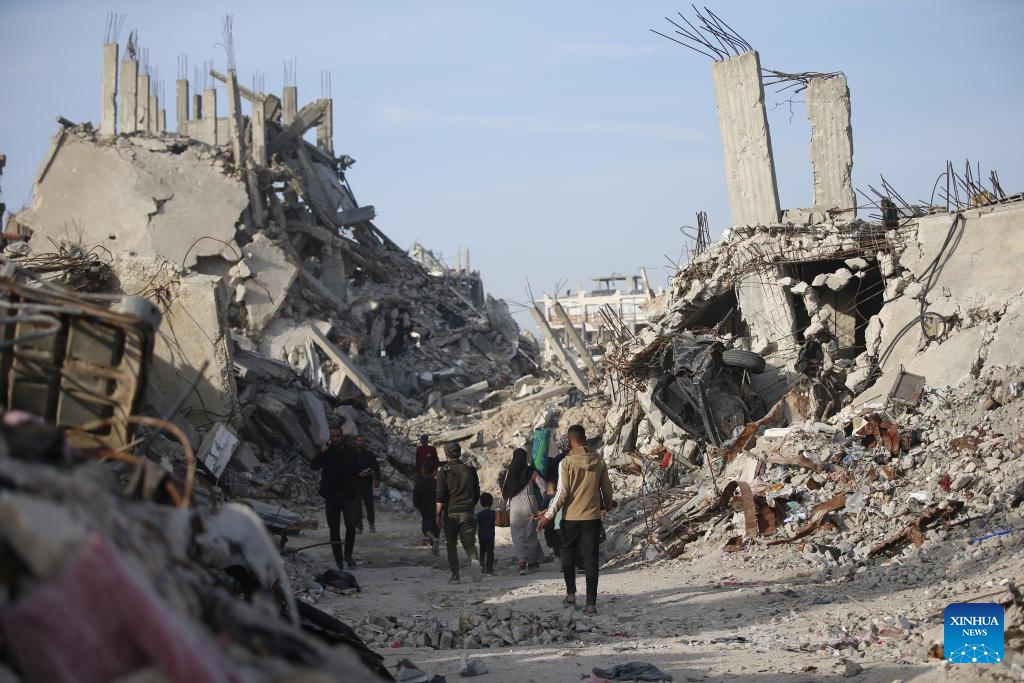 Palestinians walk among destroyed buildings in Jabalia in northern Gaza Strip on March 17, 2025. (Photo: Xinhua)