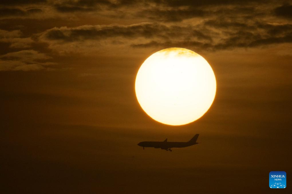 A plane flies over the Singapore Strait at sunrise on March 18, 2025. (Photo: Xinhua)