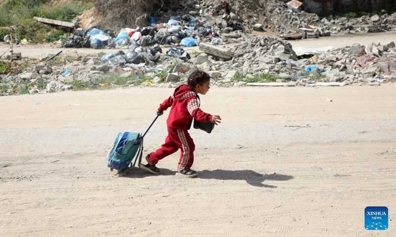 A Palestinian girl flees from the Shuja'iyya neighborhood, east of Gaza City, on March 19, 2025. Tens of Palestinian families fled their homes in various areas of Gaza on Wednesday after the Israeli army issued new evacuation orders, warning of intensified military operations. (Photo: Xinhua)