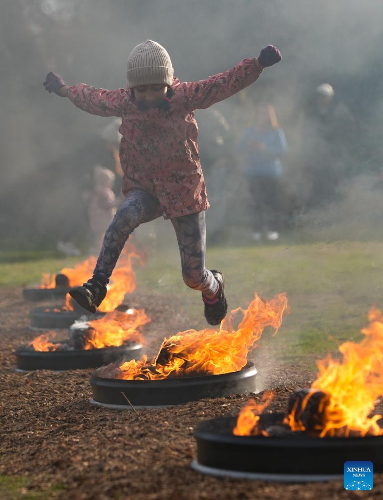 A girl leaps over a bonfire during a fire festival at Ambleside Park in West Vancouver, British Columbia, Canada, March 18, 2025. The local Iranian community participated in the fire festival on Tuesday to celebrate the upcoming Nowruz, the Iranian New Year, which falls on March 20 this year. (Photo: Xinhua)