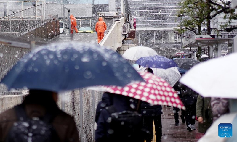 Staff members work in the snow near the Meguro Station in Tokyo, Japan, March 19, 2025. Affected by cold air, Tokyo ushered in heavy snow on Wednesday. (Photo: Xinhua)