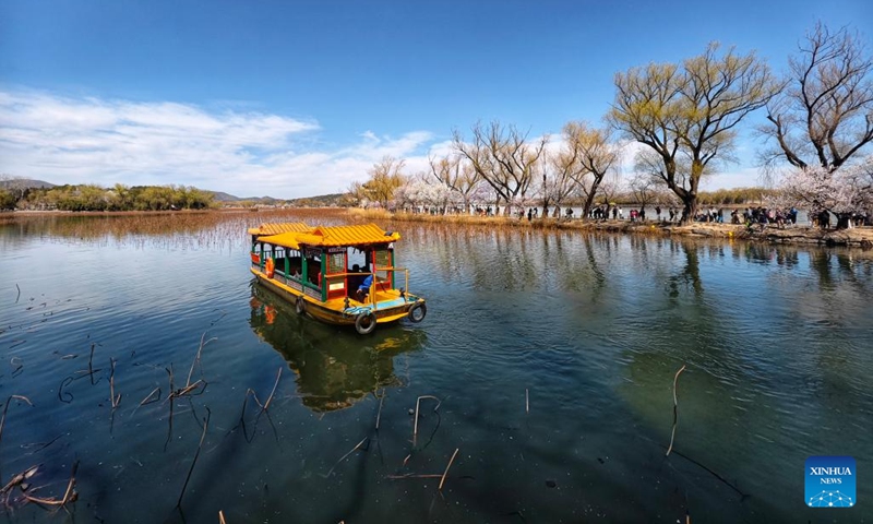 This photo taken with cellphone on March 19, 2025 shows people taking boats to enjoy flowers at the Summer Palace in Beijing, capital of China. (Photo: Xinhua)