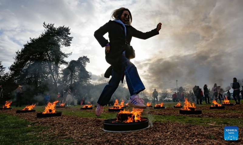 A woman leaps over a bonfire during a fire festival at Ambleside Park in West Vancouver, British Columbia, Canada, March 18, 2025. The local Iranian community participated in the fire festival on Tuesday to celebrate the upcoming Nowruz, the Iranian New Year, which falls on March 20 this year. (Photo: Xinhua)