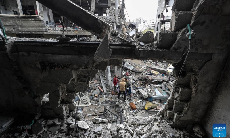 Palestinians stand among the rubble of destroyed buildings after an Israeli airstrike in the northern Gaza Strip town of Beit Lahia, on March 20, 2025. The Israeli military said on Thursday its forces had begun ground operations in northern Gaza, while Hamas' armed wing claimed responsibility for rocket attacks on central Israel, including Tel Aviv, escalating hostilities as a weeks-long ceasefire collapses. Israeli troops began what the military described as ground activity overnight in the Beit Lahia area of northern Gaza, near the coastal border. (Photo: Xinhua)