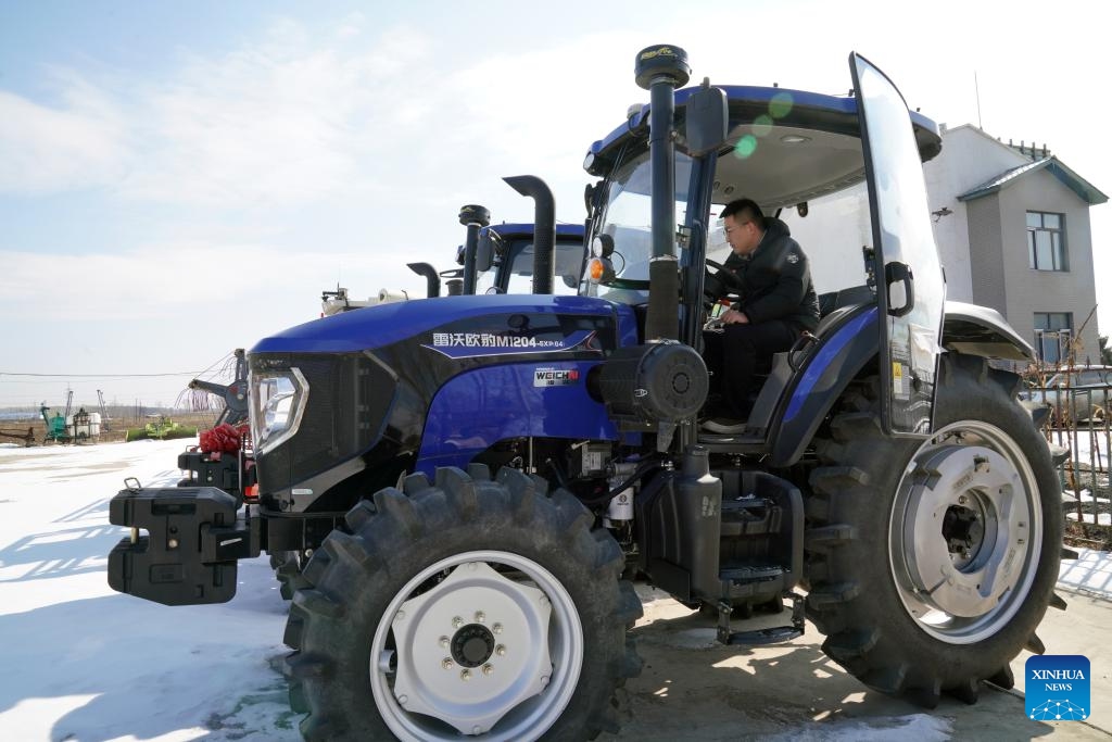 A staff member maintains the navigation system of an autonomous seeding machine at Youyi Farm Co., Ltd. under Beidahuang Group in Shuangyashan City, northeast China's Heilongjiang Province, March 19, 2025. Farming activities are in full swing across Heilongjiang, China's largest grain producing province, in early spring. (Photo: Xinhua)