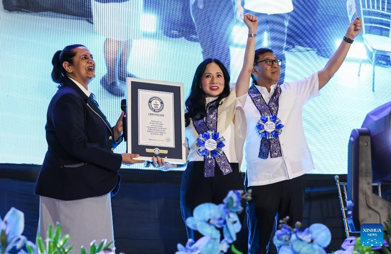 Guinness World Record adjudicator Sonia Ushirogochi (L) hands a Guinness World Records certificate to Malabon City Mayor Jeannie Sandoval (C) in Malabon City, the Philippines, on March 21, 2025. The city successfully achieved the Guinness World Record for the longest line of bowls of noodles with 6,549 bowls. Photo: Xinhua