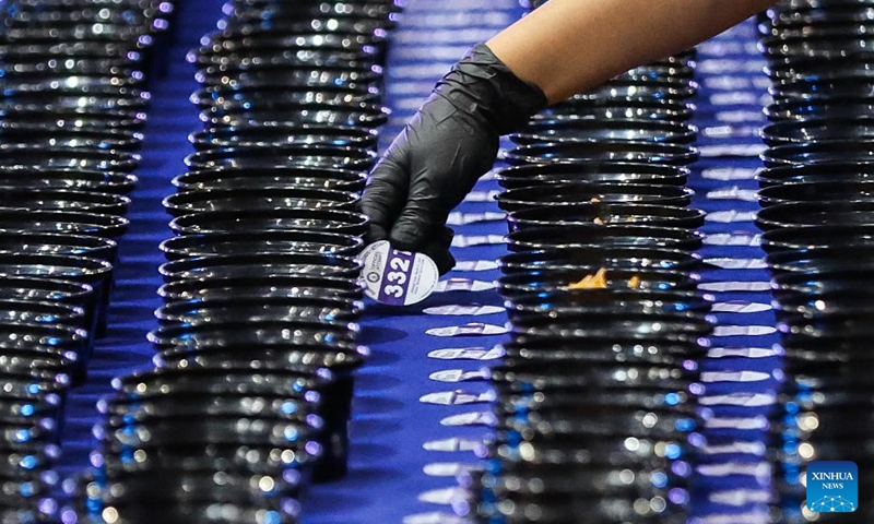 A volunteer puts a label number on a noodle bowl during Malabon City's attempt to break the Guinness World Record for the longest line of bowls of noodles in Malabon City, the Philippines, on March 21, 2025. The city successfully achieved the Guinness World Record for the longest line of bowls of noodles with 6,549 bowls. Photo: Xinhua