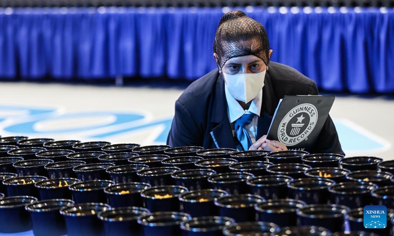 Guinness World Record adjudicator Sonia Ushirogochi checks the noodles bowls during Malabon City's attempt to break the Guinness World Record for the longest line of bowls of noodles in Malabon City, the Philippines, on March 21, 2025. The city successfully achieved the Guinness World Record for the longest line of bowls of noodles with 6,549 bowls. Photo: Xinhua