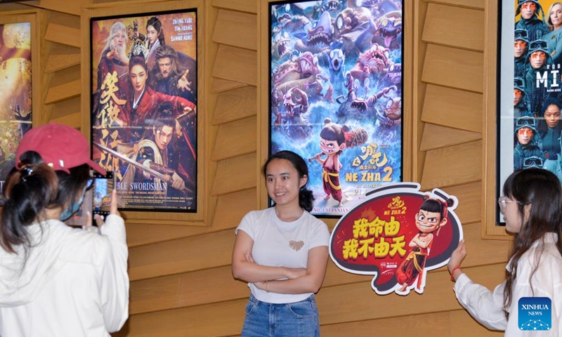 A viewer poses with a poster of Ne Zha 2 at a cinema in Jakarta, Indonesia, March 21, 2025. Chinese animated blockbuster Ne Zha 2, the highest-grossing animated film of all time, was officially in cinema in Indonesia on Friday. Photo: Xinhua